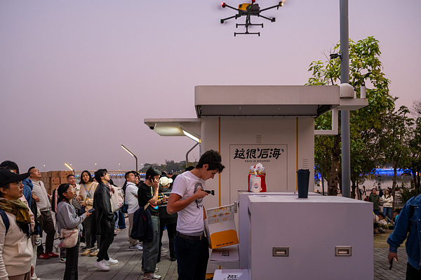 在深圳，外國游客體驗(yàn)無人機(jī)外賣送餐。