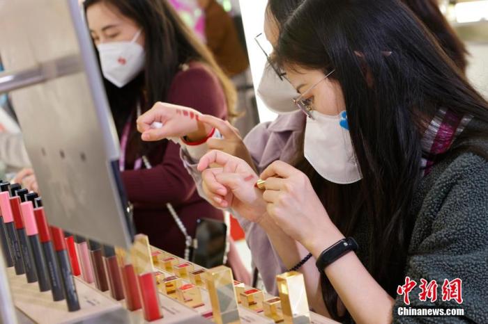 圖為女生正在體驗(yàn)口紅產(chǎn)品。 殷立勤 攝