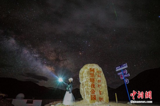 圖為6月20日晚，游客“打卡”西藏阿里暗夜公園，天上是銀河與流星（右上角）。曹枝清 攝