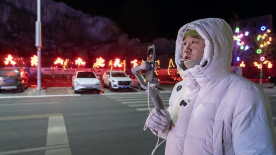 在吉林市阿什哈達(dá)霧凇觀景帶，霧凇播報(bào)員正在直播。新華社記者 李典 攝