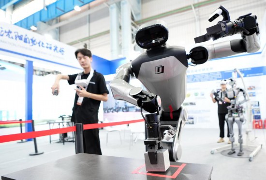9月5日，在沈陽的2025全球工業(yè)互聯(lián)網(wǎng)大會的展覽區(qū)現(xiàn)場，中國科學院沈陽自動化研究所的機器人工程師在調(diào)試具身智能操作系統(tǒng)。新華社記者 李鋼 攝
