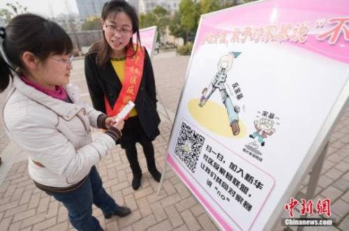 資料圖：今年3月8日，安徽合肥新華社區(qū)志愿者夏一瓊(右)向市民普及反家暴相關(guān)法律知識。鐘欣 攝