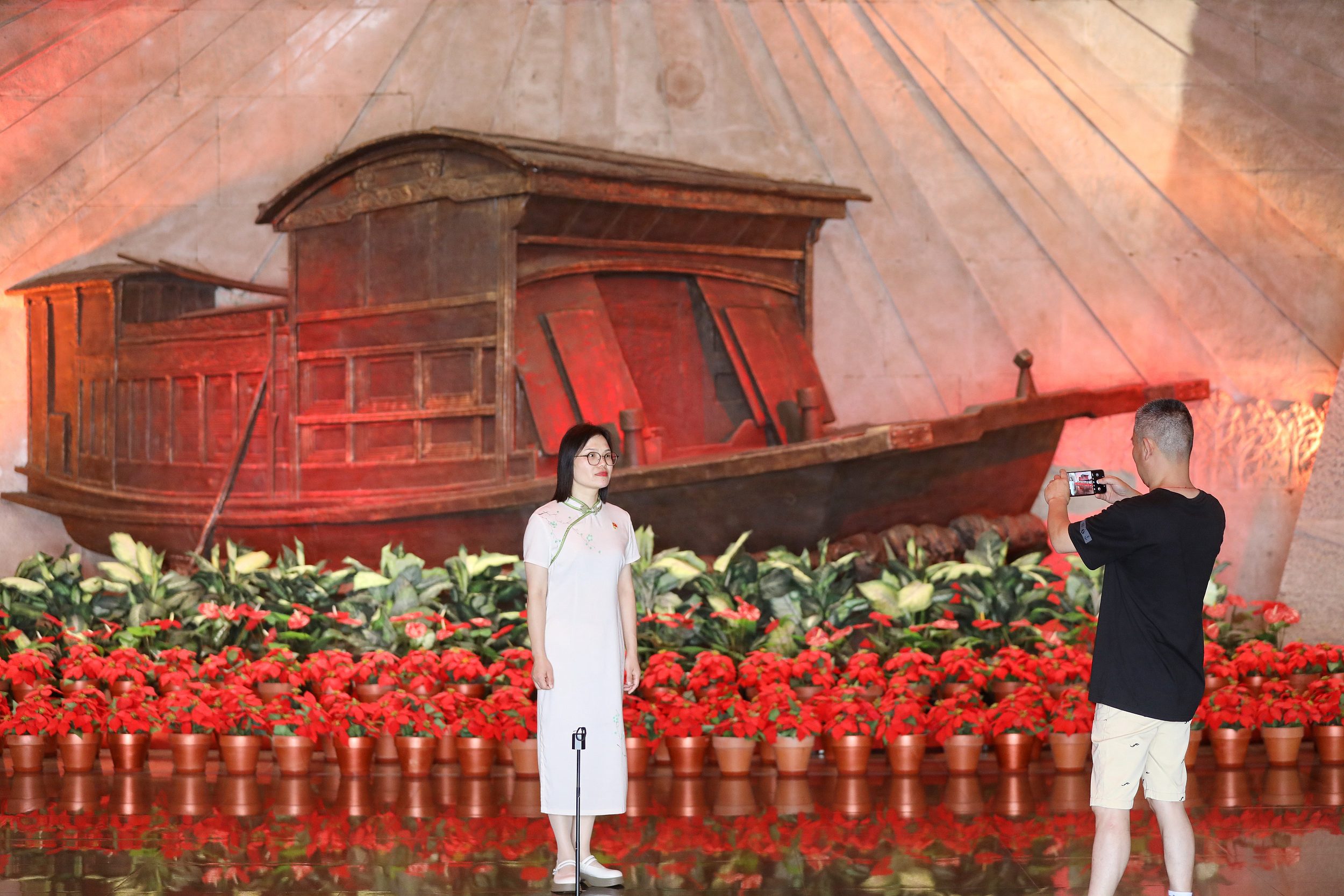 2025年6月24日，浙江嘉興，游客在南湖革命紀念館與紅船雕塑合影。（圖片來源：視覺中國）